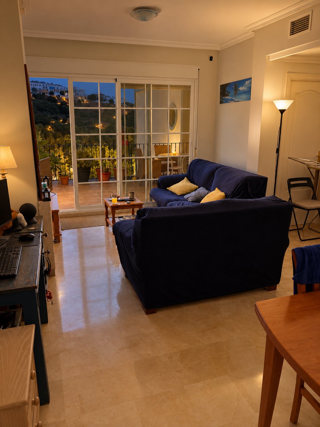 The Casa del Mar living room before, with navy sofas and a polished marble floor