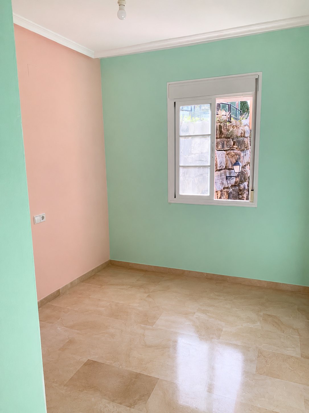 The Casa del Mar guest bedroom before, with mint green and peach walls