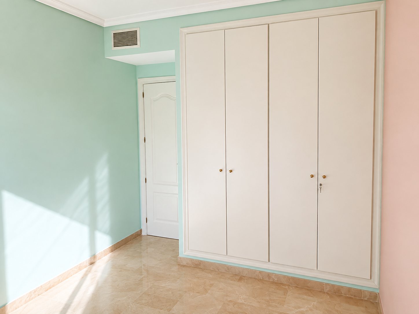 The guest bedroom wardrobe wall before, with mint green and peach walls