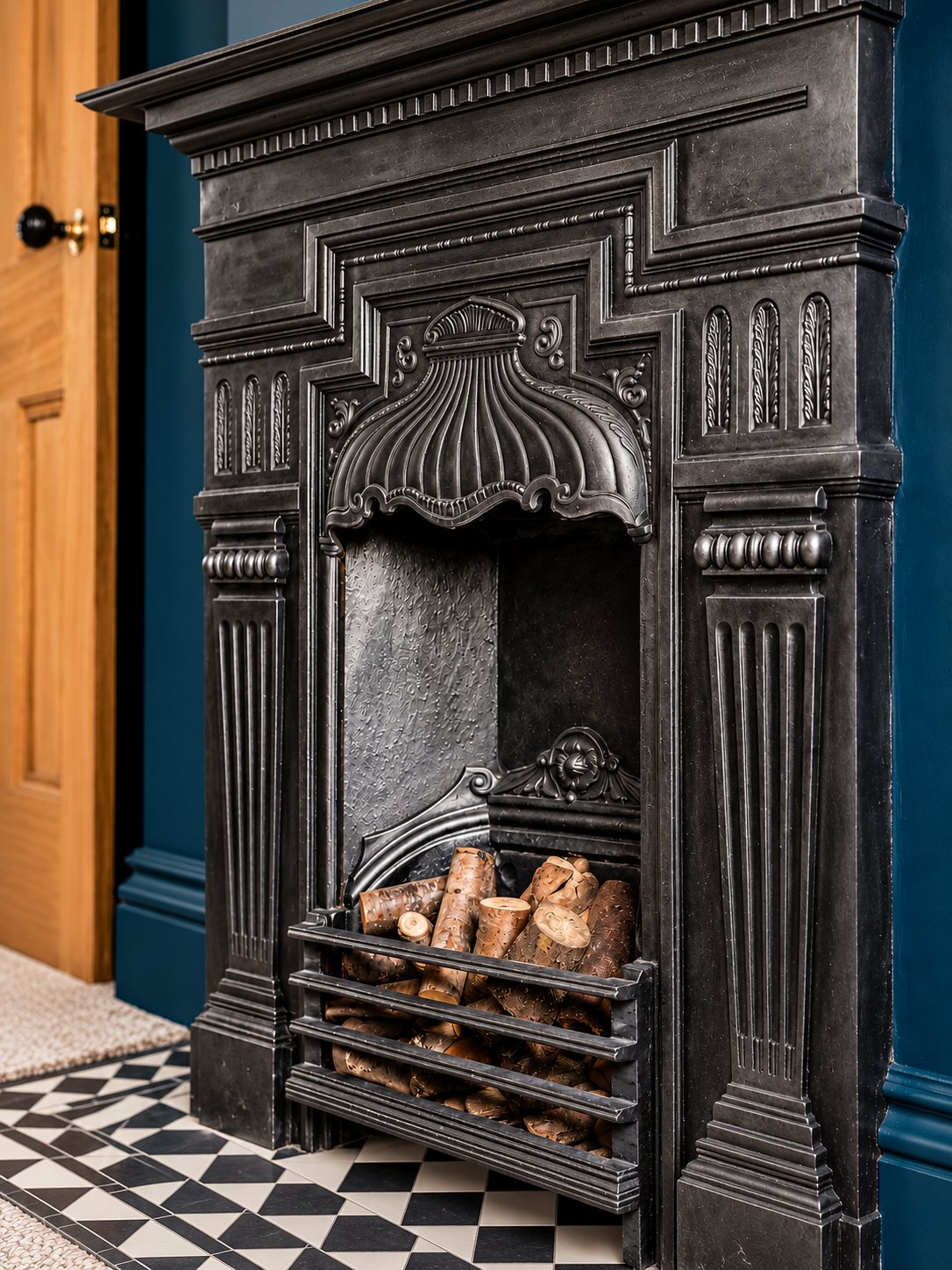 Victorian cast-iron fireplace set against deep blue walls above a checkerboard hearth