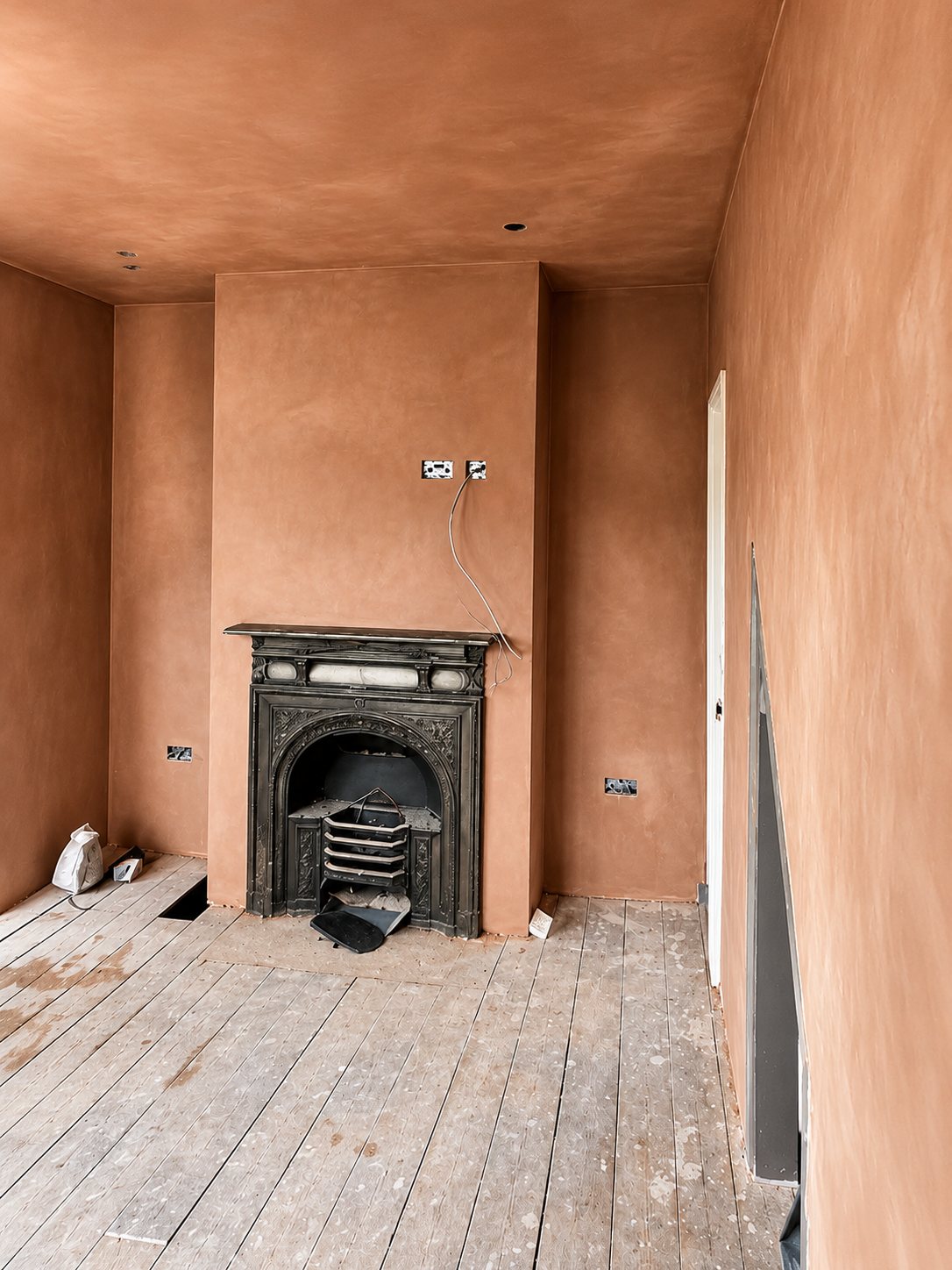 Freshly plastered dining room with an antique cast-iron fireplace