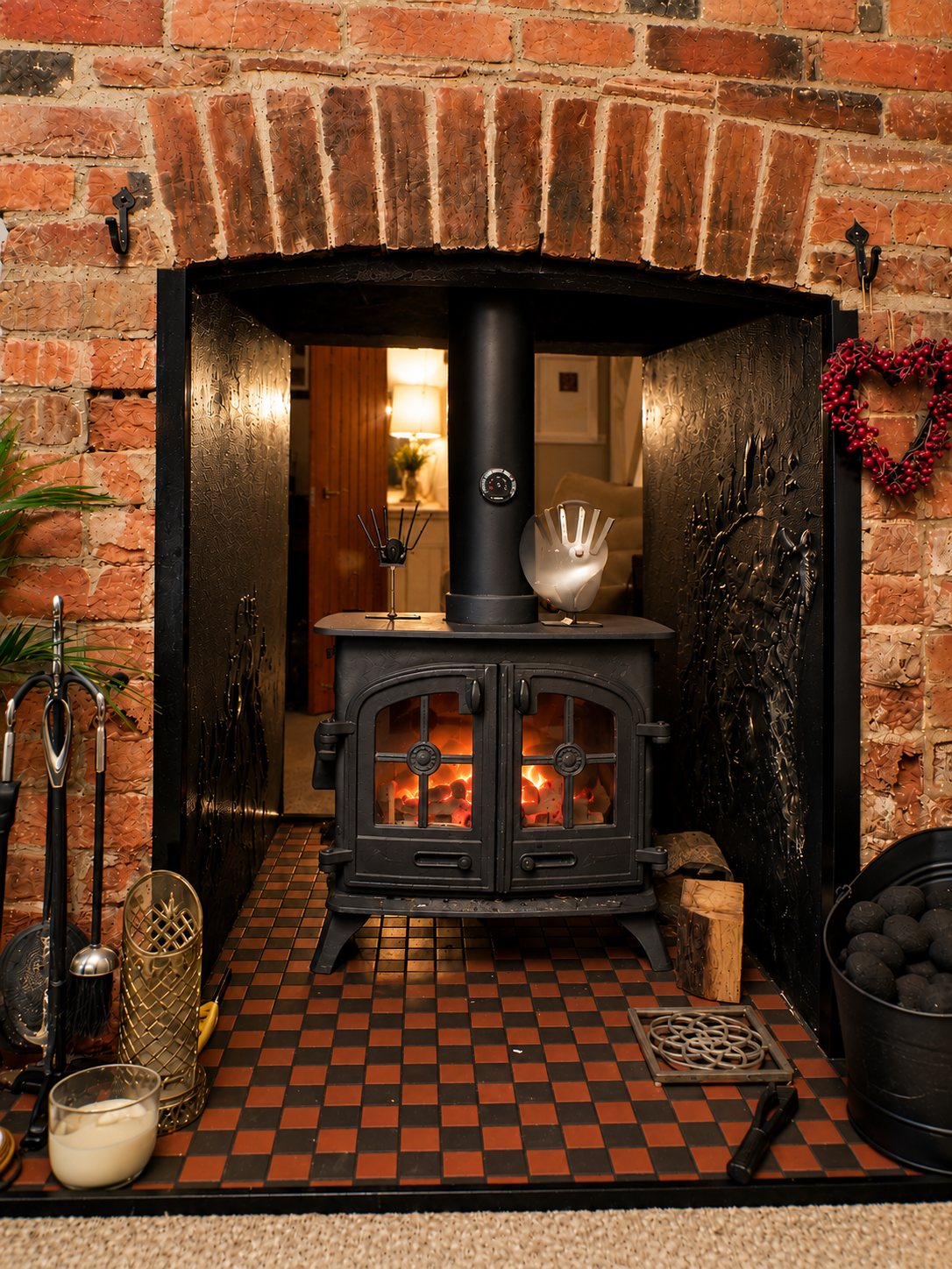 The original wood-burning fireplace in the workers’ cottage, set in red brick above a quarry-tiled hearth