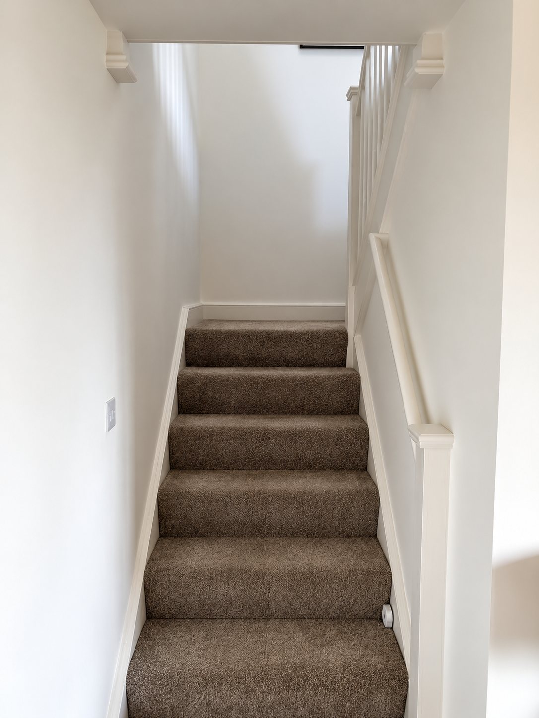 The staircase to the bedroom before, with plain white walls